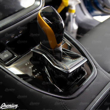 Lift shift boot trim so that the chrome ring is close to level with the top of the shift knob.