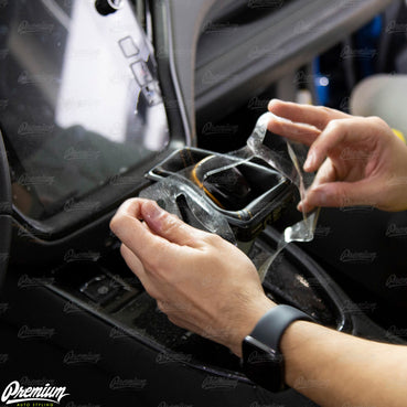 Spray the adhesive side of the protection film with either surface lube or 16oz of water with 1 drop of dish soap. Carefully place the cut out of the overlay over the shift knob/shift boot ring.