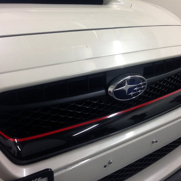 Installed on the upper portion of the grille.